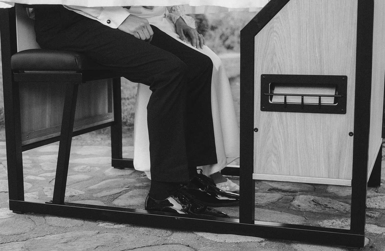 Black and white detail of the enclosed booth's wooden base and print slot