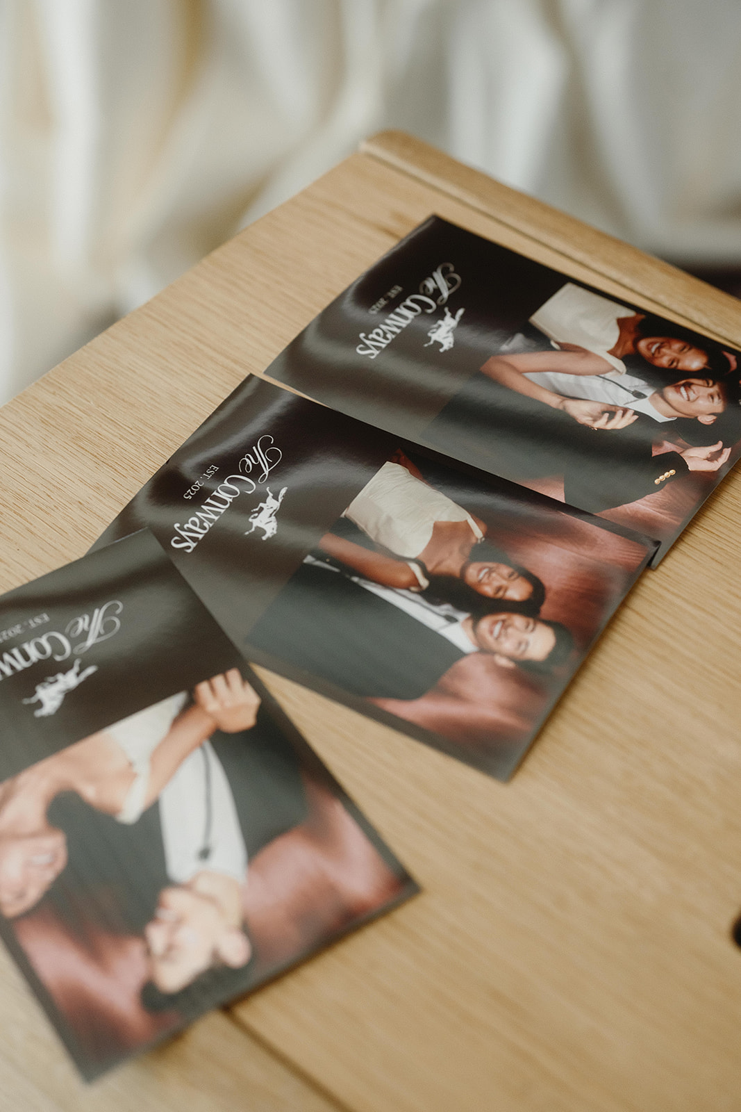 Four photo booth prints fanned out on a wooden table