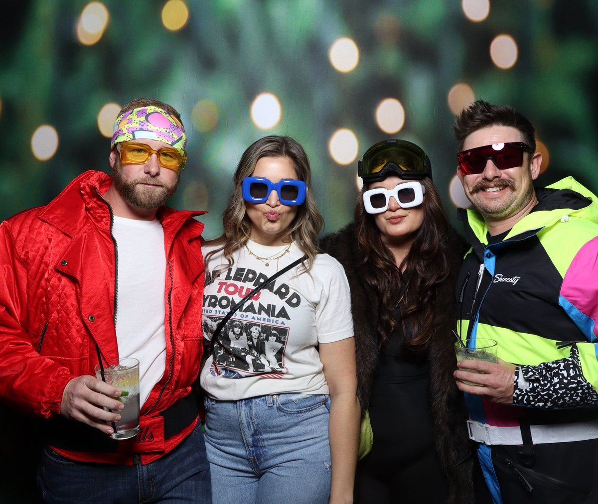 Four guests in eighties costume at a holiday party booth