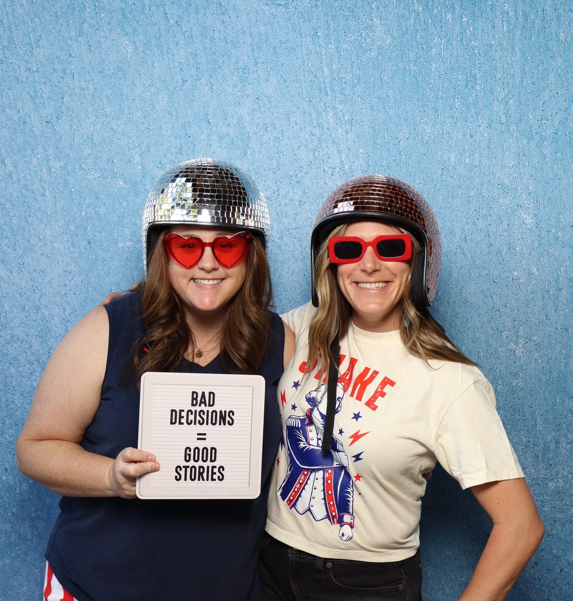 Two guests in novelty hats and sunglasses at a company picnic