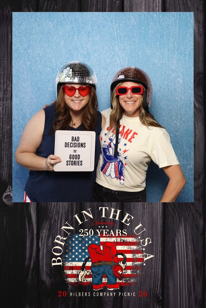 Two guests in disco-ball helmets holding a Bad Decisions Good Stories sign on a Hilbers company picnic template