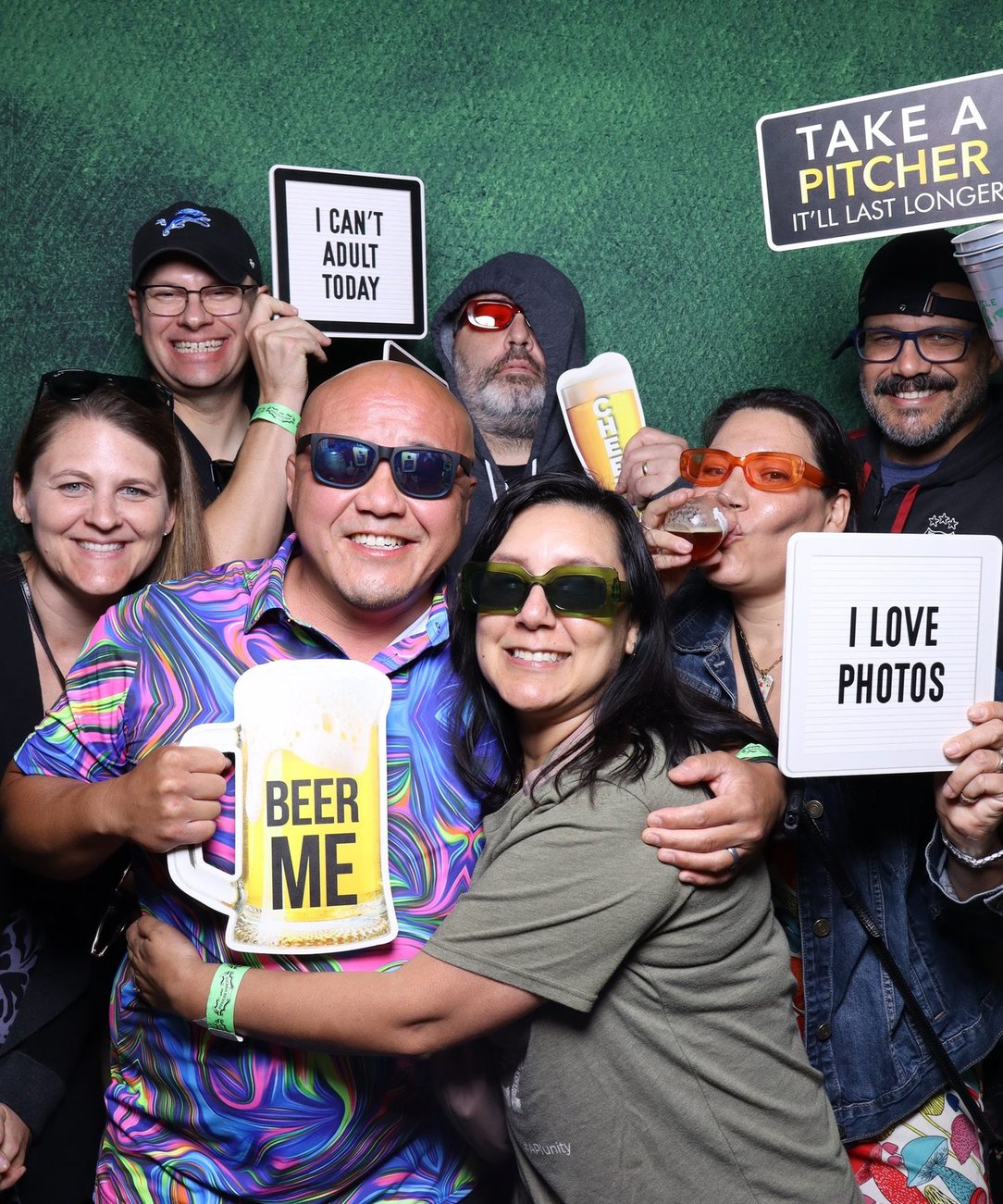 Colleagues holding I love photos signs at the booth
