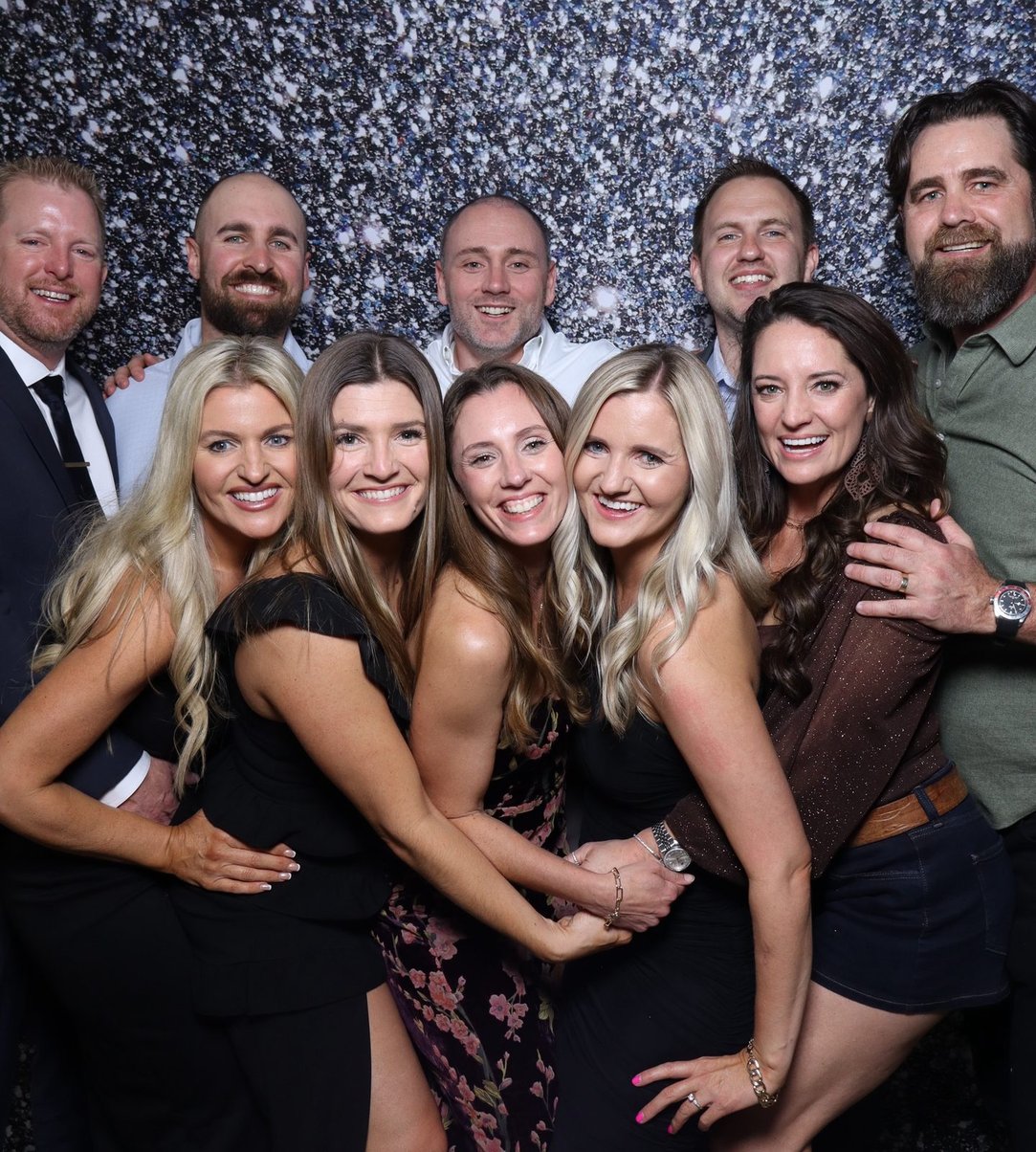 Friends arm in arm against the sequin backdrop