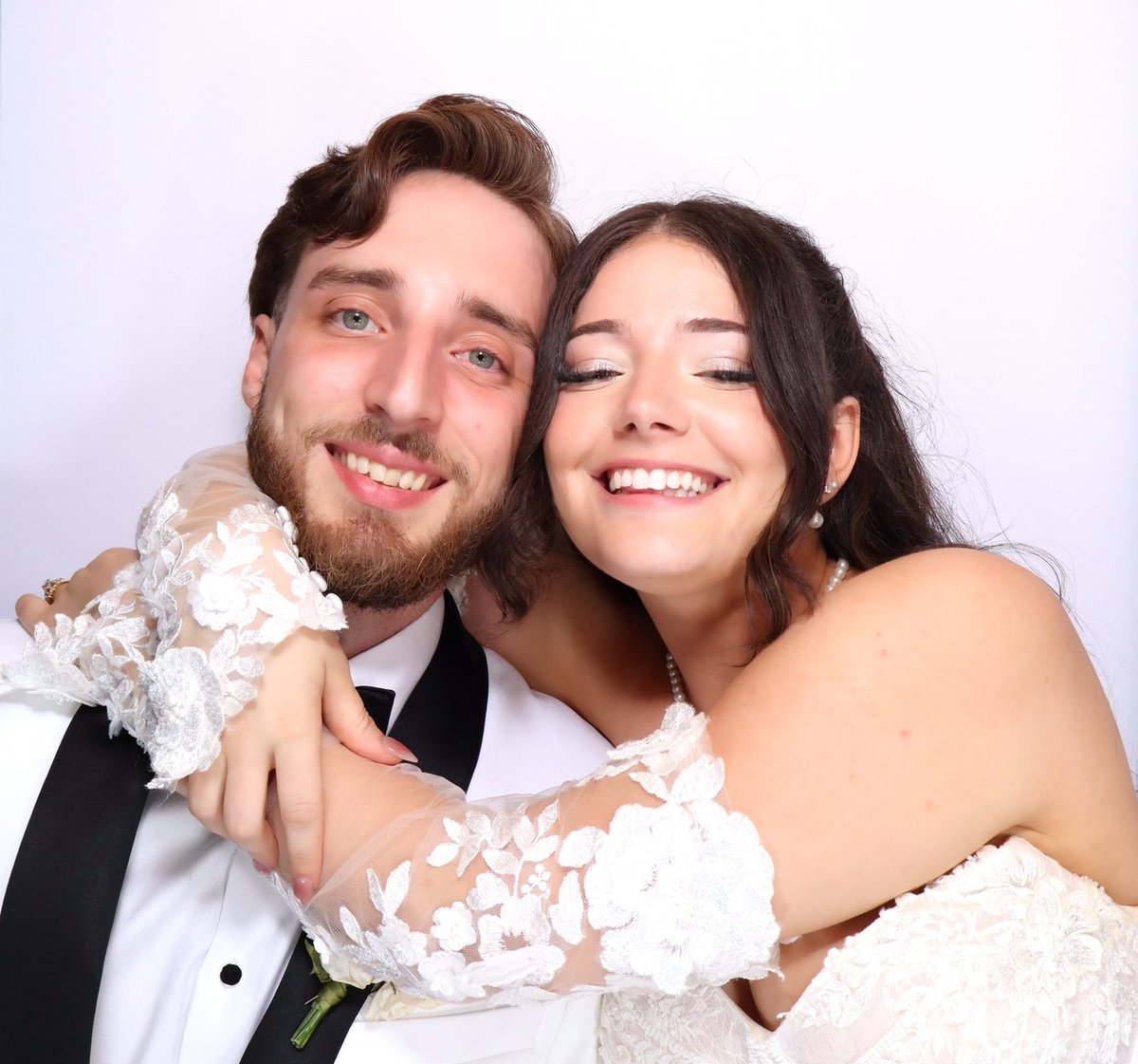 A bride and groom cheek to cheek in the booth