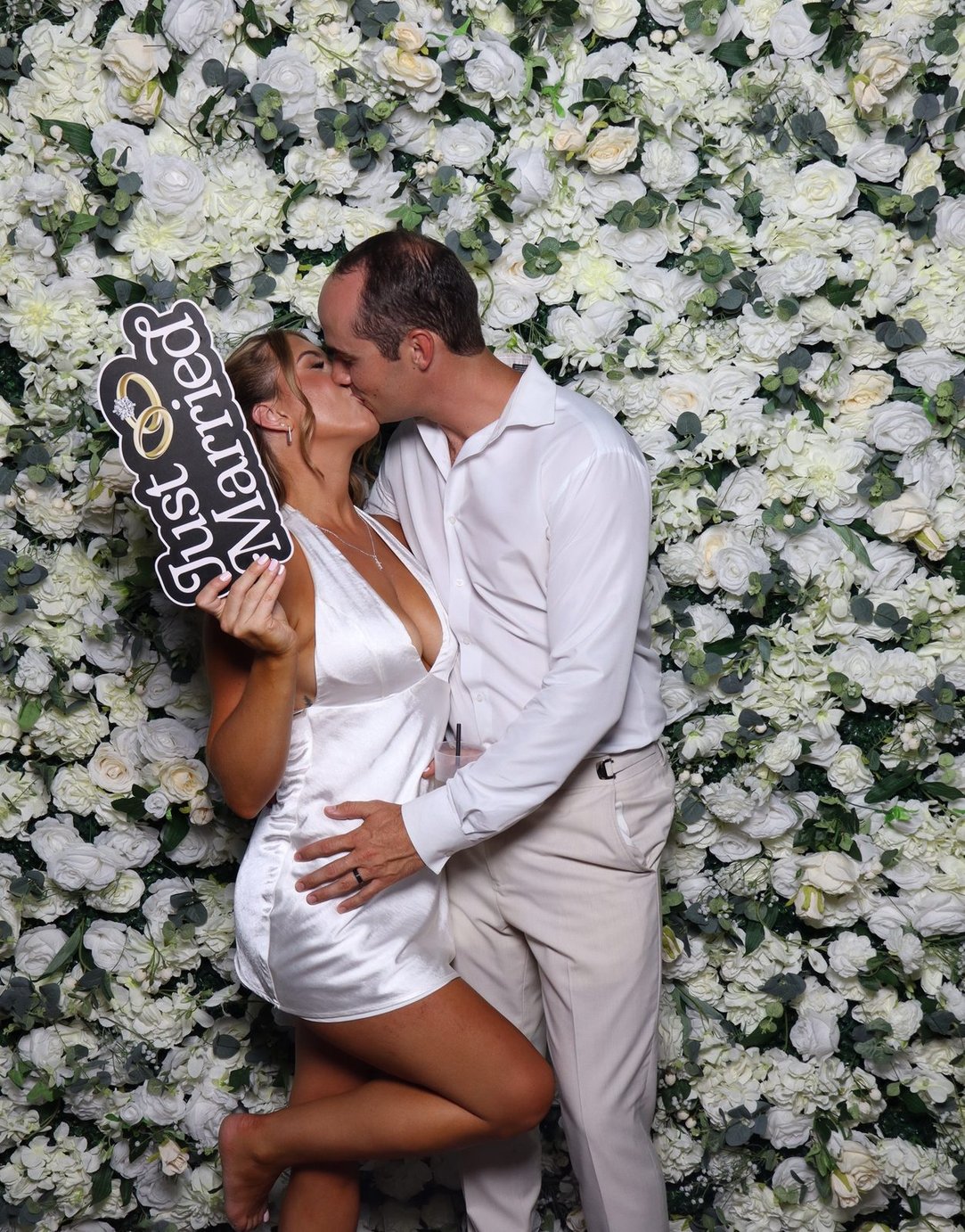 A couple kissing with a just married sign