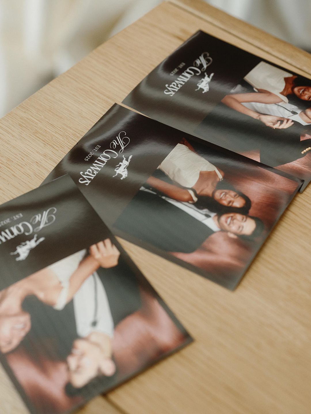 Two photo booth prints resting on a wooden table
